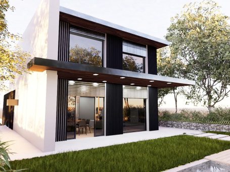 Casa moderna de dos pisos con fachada oscura y grandes ventanales rodeada de vegetación.